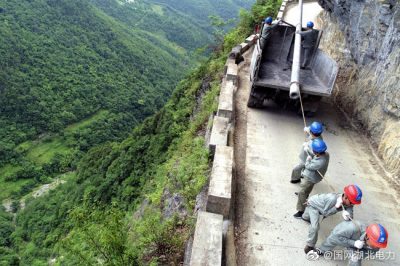 龍坪供電所用人力推車(chē)將8米長(cháng)水泥電桿轉運到作業(yè)點(diǎn)